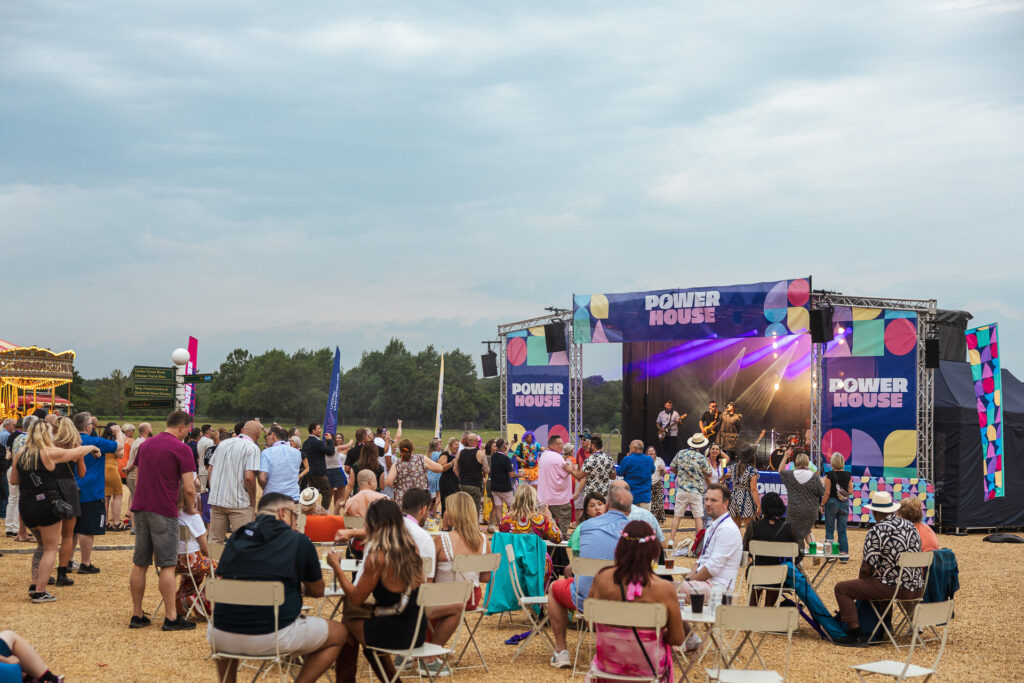 Guests enjoying a Clownfish outdoor summer event with a festival stage