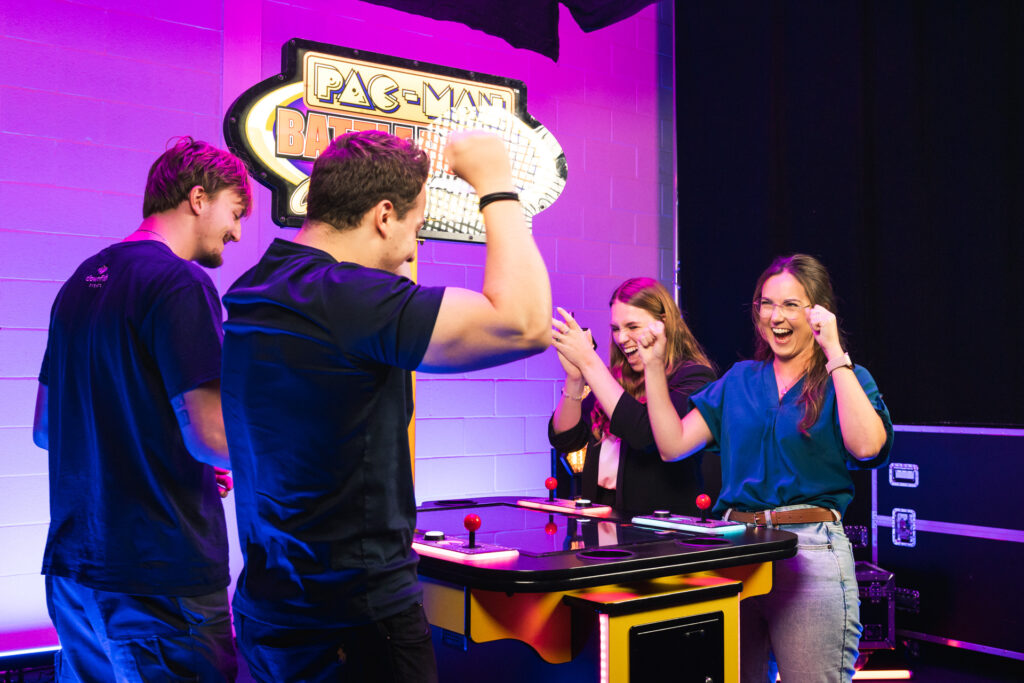 Colleagues celebrating at a retro arcade game hosted by Clownfish